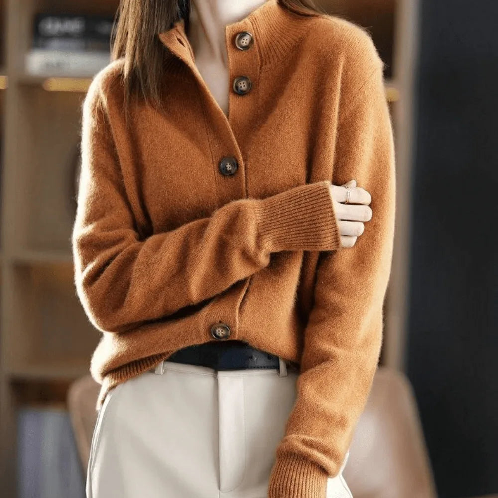 Camel cashmere cardigan with funnel neck and button placket, styled with cream leather trousers