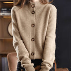 Beige cashmere cardigan with stand collar and five button closure, shown buttoned up to the neck