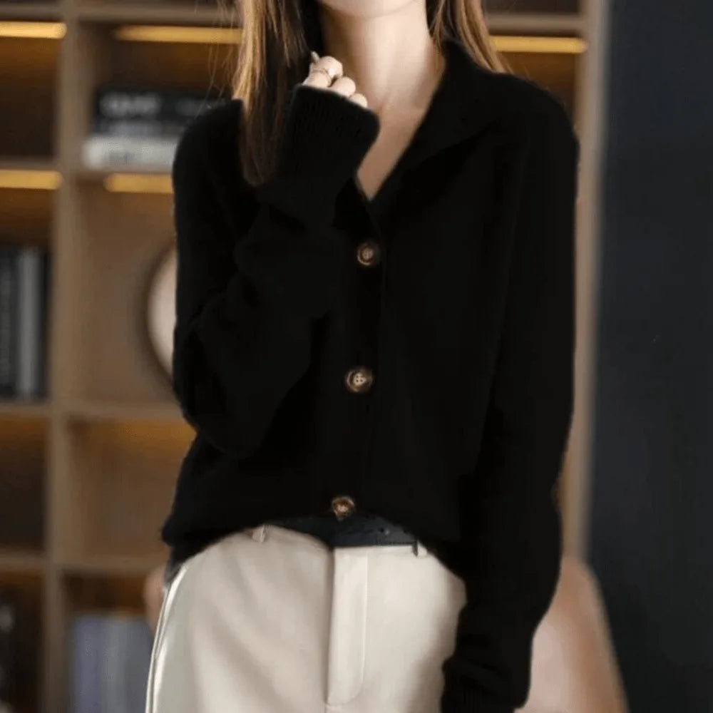 Black cashmere cardigan with notched collar and ribbed cuffs, worn open over cream leather trousers