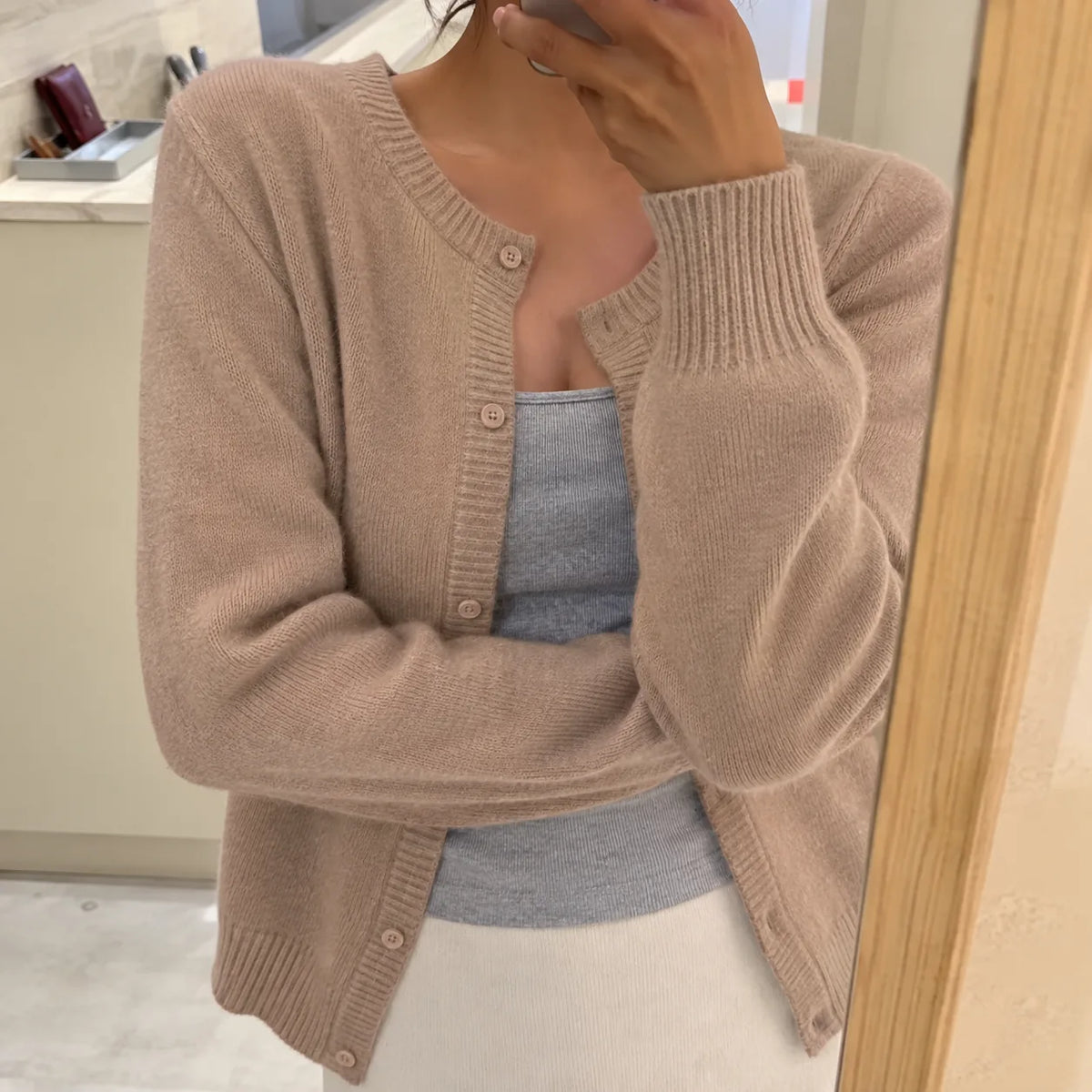 Taupe knitted cardigan with round neckline and button placket, worn over a grey camisole