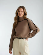 Front view of the brown jumper with relaxed oversized sleeves, worn with cream trousers and a black leather belt
