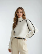 Cream white polo neck jumper with contrasting black piping detail across the shoulders and sleeves, front view