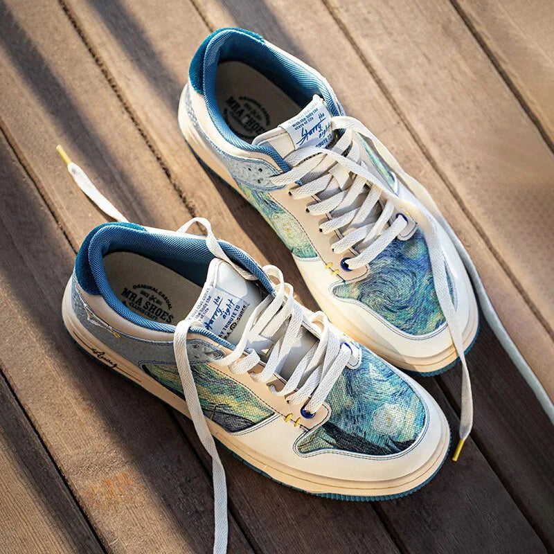 Top down view of a matching pair of art print trainers with cream laces on a wooden deck