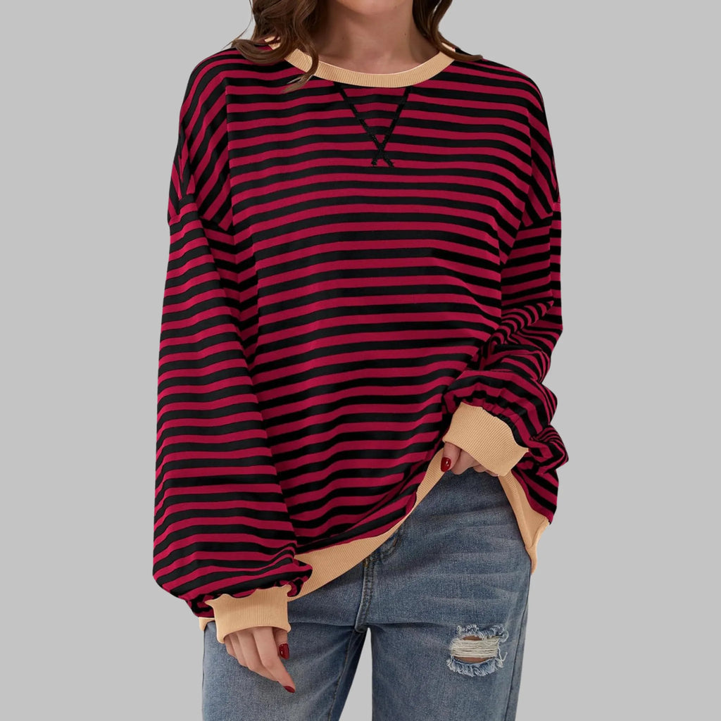 Close-up of contrast ribbed crew neckline with visible loop label detail on striped sweatshirt