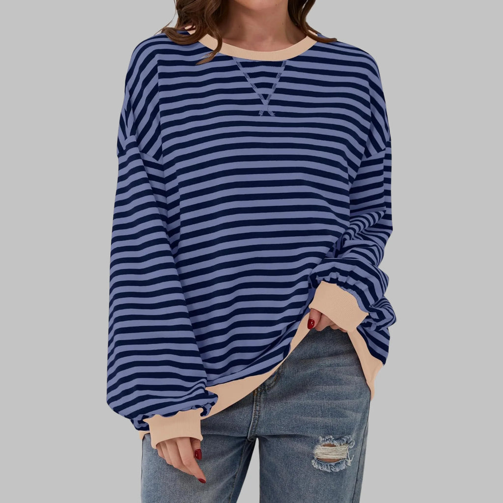Close-up of drop shoulder seam and ribbed cuff detail on an oversized striped sweatshirt