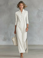 Front view of an off-white maxi dress with a button placket, stand collar and black striped side trim