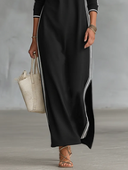 Cropped view of the black maxi dress showing the side split and white stripe detail along the leg