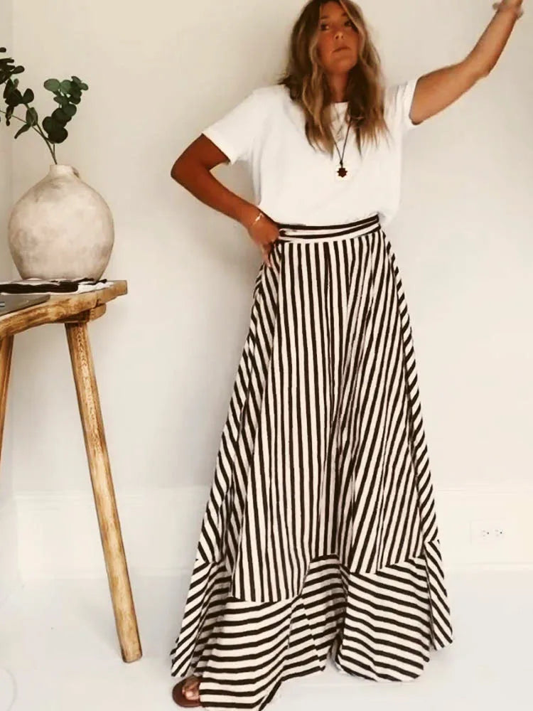 Model wearing a striped maxi skirt and white t-shirt, showing the flowing tiered hemline