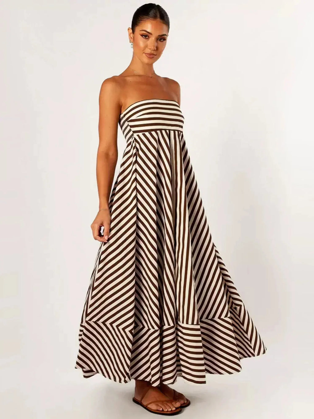 Three-quarter view of the striped maxi dress highlighting the dramatic tiered, flared skirt in motion
