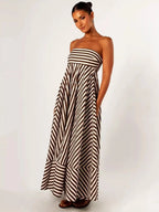 Side view of the striped maxi dress paired with flat sandals, showing the dress falling to the ankle