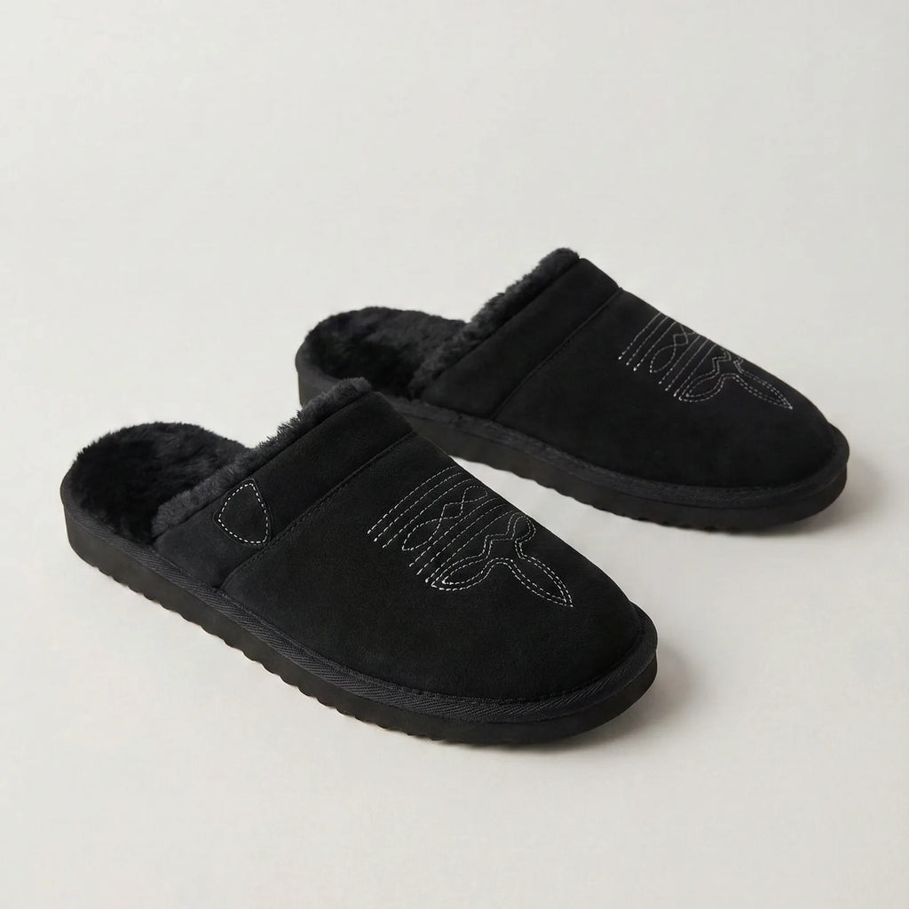 Side view of black suede slipper with tan collar, fur lining and brown sole