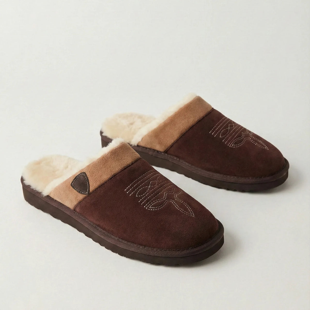 Pair of dark brown suede slippers with tan trim shown side by side