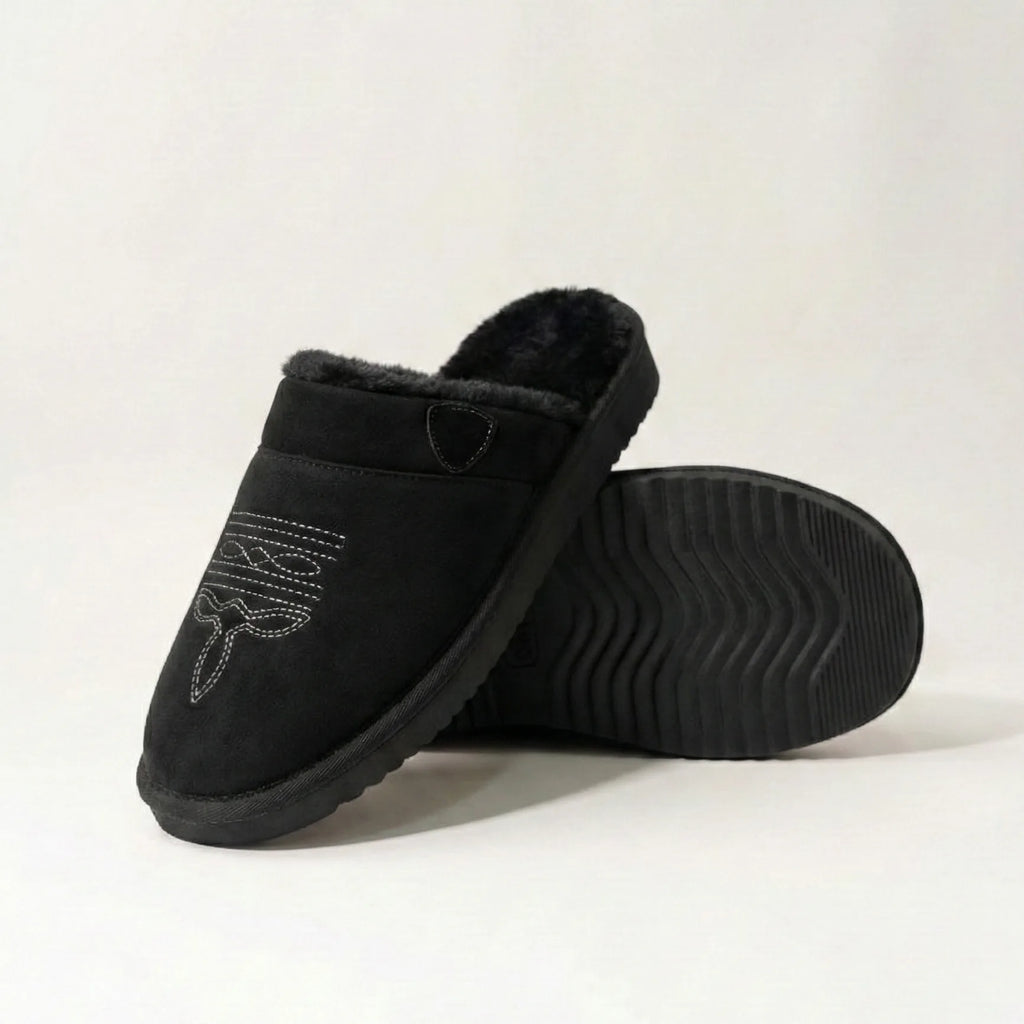 Three-quarter view of black suede slipper with tan cuff and embroidered toe stitching