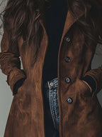 Detail shot of the button-front placket and side pocket on a brown longline suede-style coat