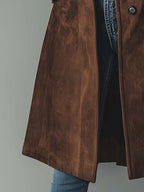 Close-up of the coat hem and side vent, showing the flowing longline cut and fabric drape
