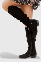 Black suede knee-high boot shown in profile with visible side zipper and low stacked heel