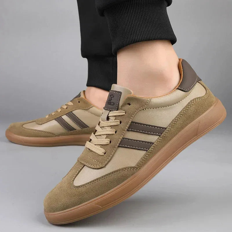 Close-up side angle of khaki suede trainer on foot with dark stripe detailing and cotton laces