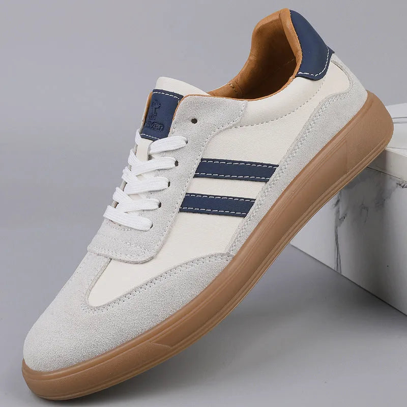Side view of off-white trainer with navy leather stripes and gum sole against marble backdrop