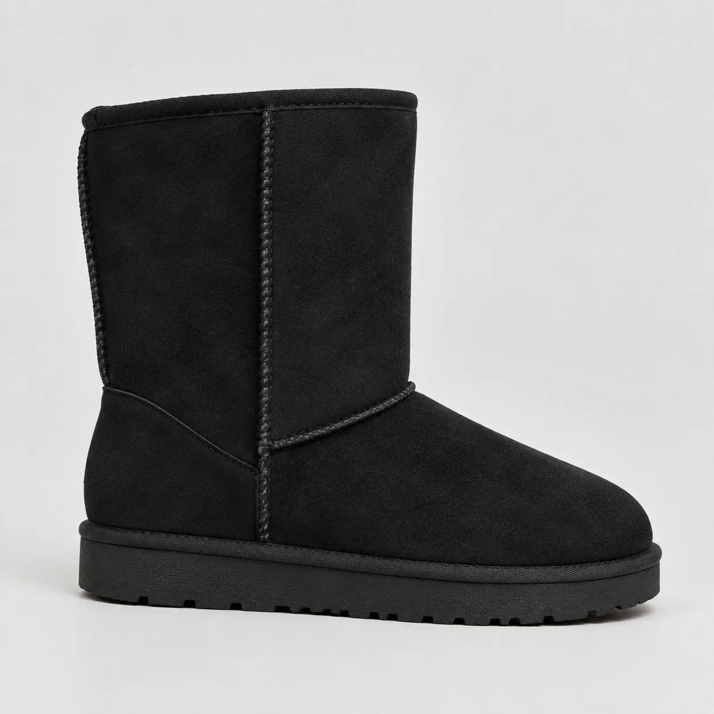 Side view of a black suede mid-calf boot with braided trim and a chunky treaded sole