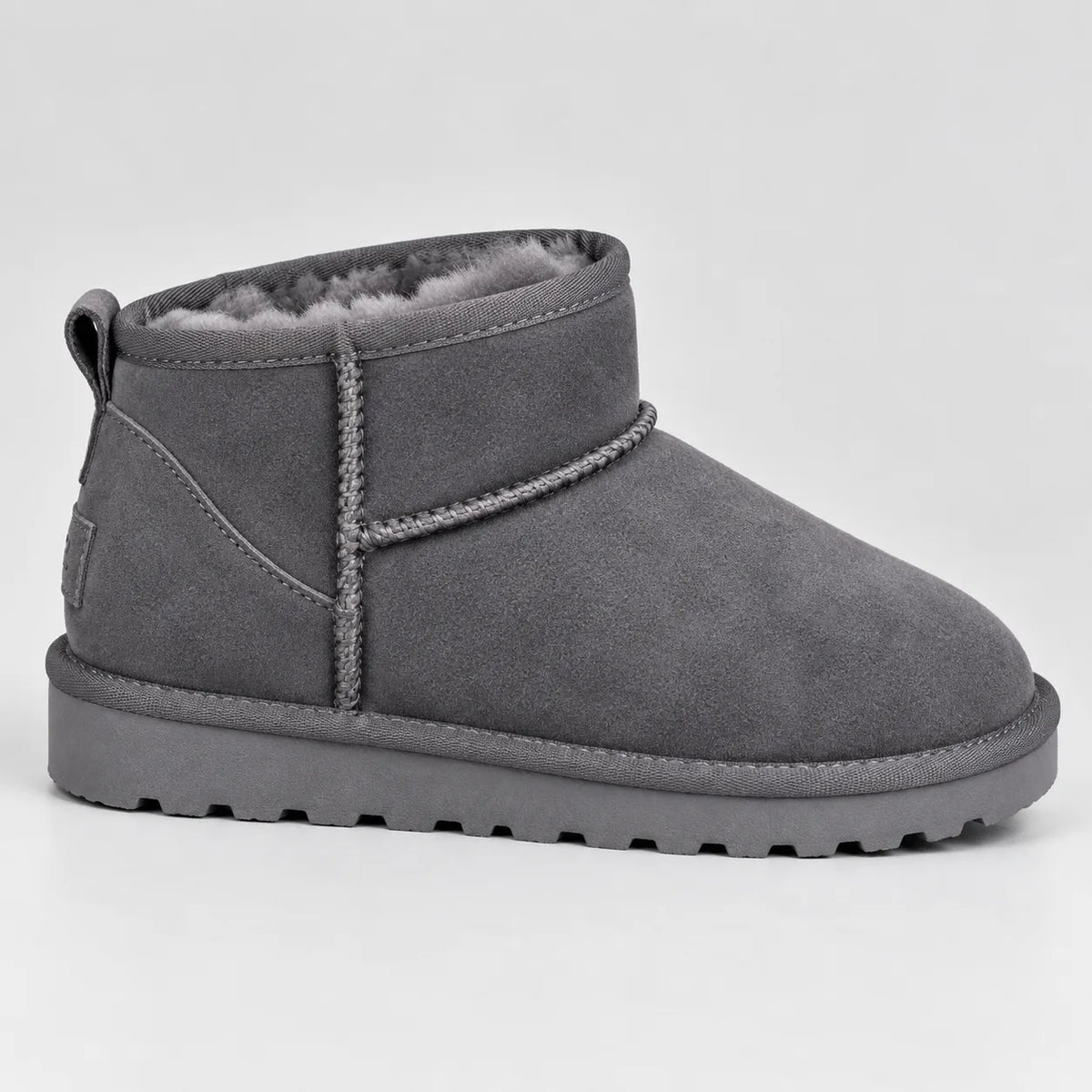 Grey suede mini ankle boot shown from the side, revealing soft grey faux-fur trim and textured sole