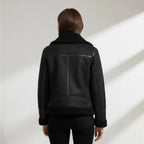Back view of the black suede biker jacket showing the structured seaming and shearling cuffs