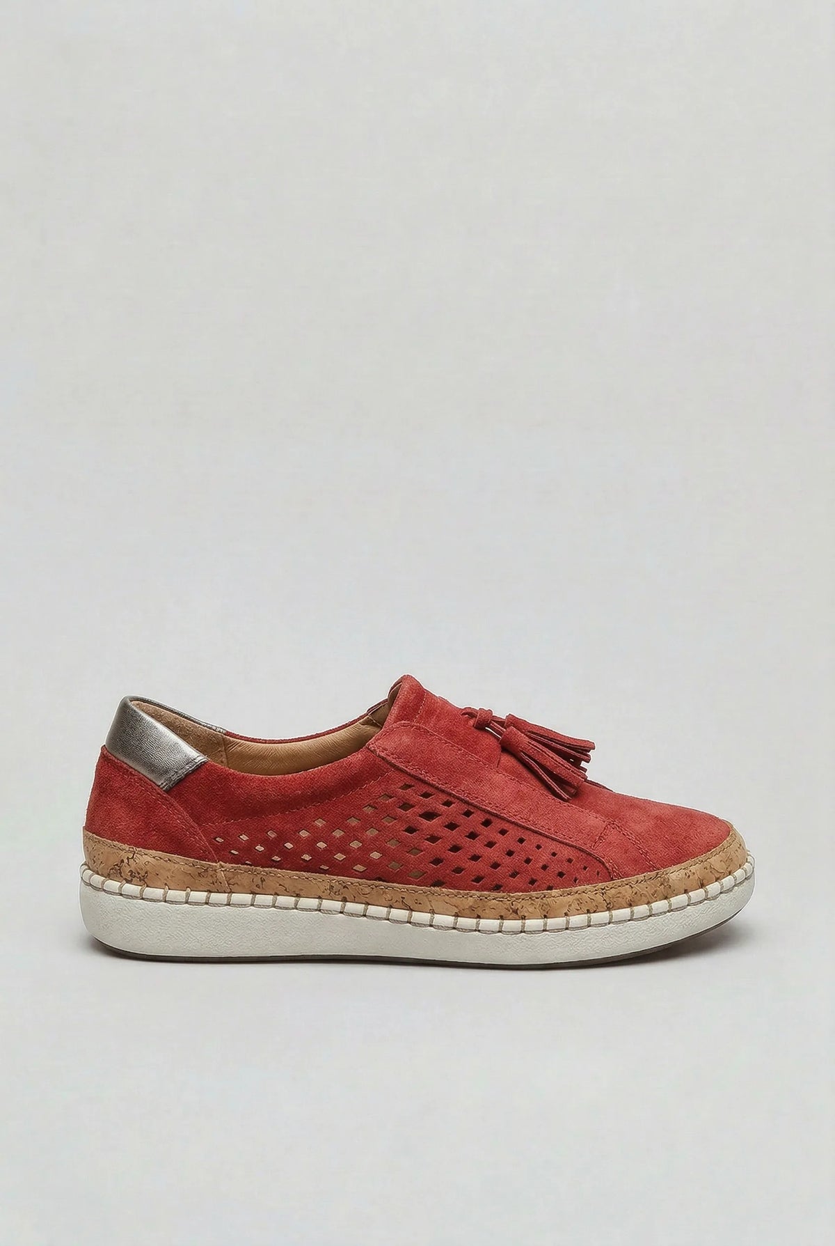 Side view of a red suede slip-on trainer with perforated panel, tassel detail and cork-trimmed white sole