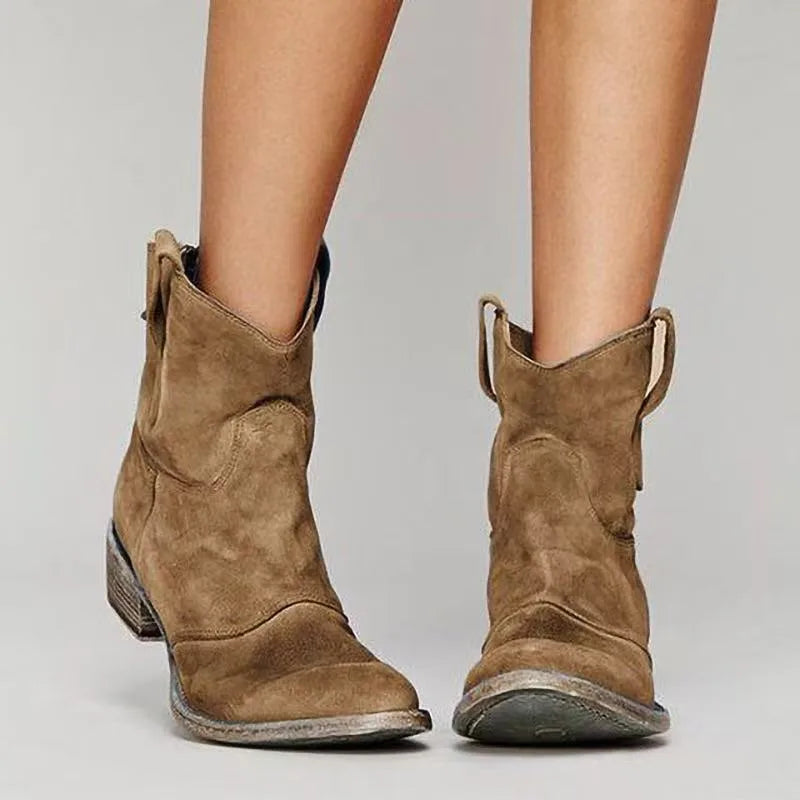 Close-up front angle of light brown suede western-style ankle boots showing stitched seam detail