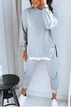 Grey marl oversized sweatshirt and jogger set styled with white trainers, shown with a layered white hem detail