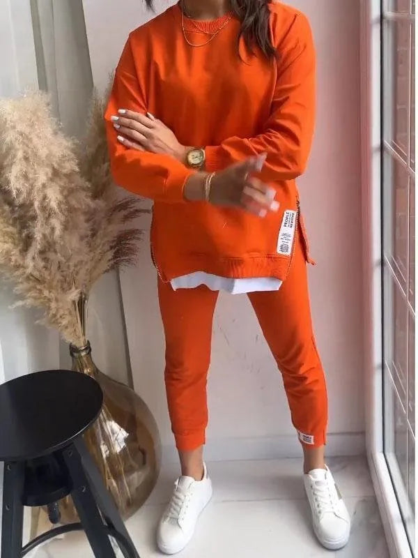 Bright orange sweatshirt and jogger co-ord shown from the front, highlighting the relaxed crew neckline