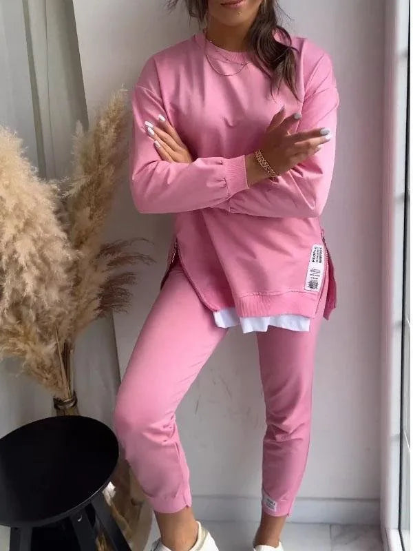 Close-up front view of the pink sweatshirt showing the side zip pocket, layered hem and ribbed cuffs