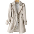 Beige trench coat displayed on a wooden hanger, showing the wide lapel collar and tortoiseshell button placket