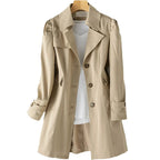 Beige trench coat on hanger with front fully visible, highlighting the fitted waist seam and flap pockets