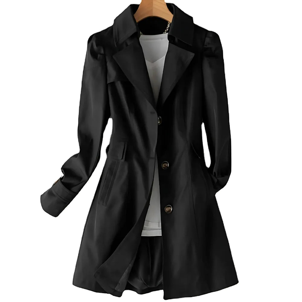 Black tailored trench coat on hanger with notched collar and button-front fastening, shown open over a white top