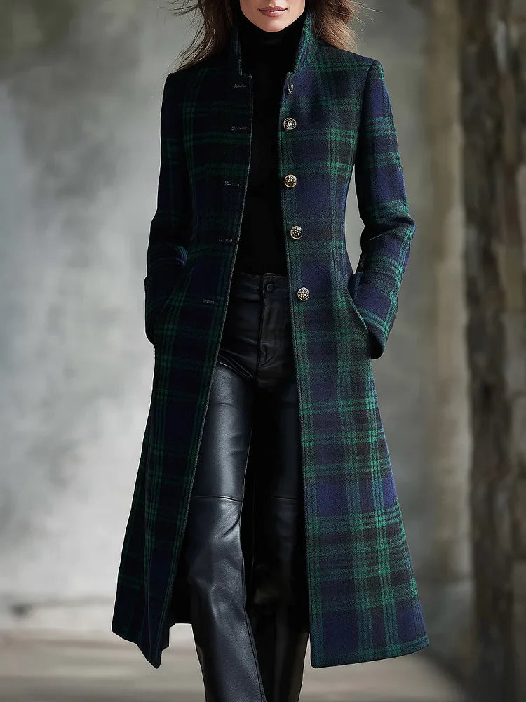 Front view of a woman wearing a navy and green tartan check midi coat with a high stand collar and gold buttons
