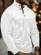 Side view of a man wearing a white cable-knit quarter-zip jumper with button stand collar, outdoors at night