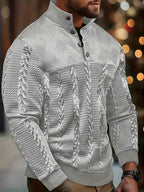 Detail view of the cable-knit sleeve and ribbed cuff on the white jumper