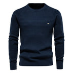 Navy blue textured waffle-knit jumper with ribbed crew neck, cuffs and hem, worn by a man, front view