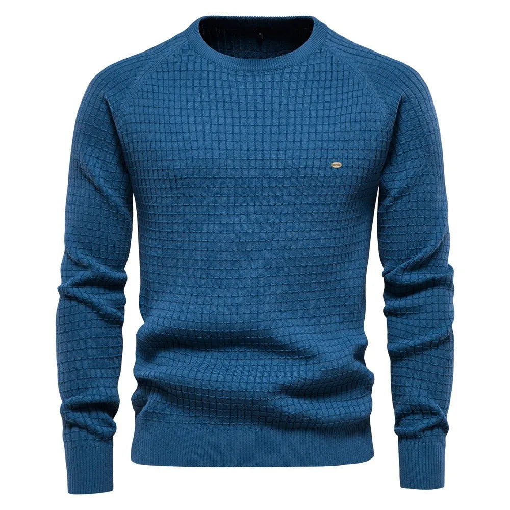 Steel blue textured knit jumper with long raglan sleeves and small metal logo tag on the chest
