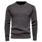 Dark grey waffle-textured knit jumper with ribbed crew neckline, shown on a male model from the front