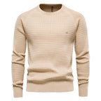 Beige textured knit jumper with ribbed trim and subtle tonal logo badge on the left chest