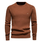 Rust brown textured knit jumper with long sleeves and ribbed cuffs, front view on a male model