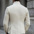 Back view of the white textured jacket showing the stand collar and tailored silhouette across the shoulders