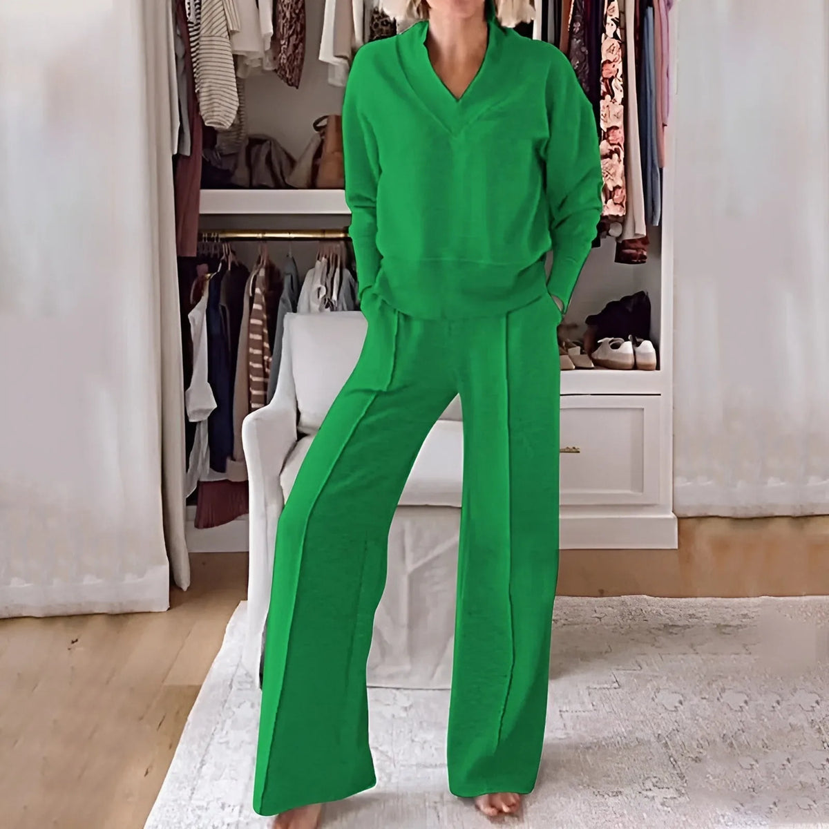 Model wearing a bright green V-neck jumper and wide-leg trousers two-piece set with hands in pockets