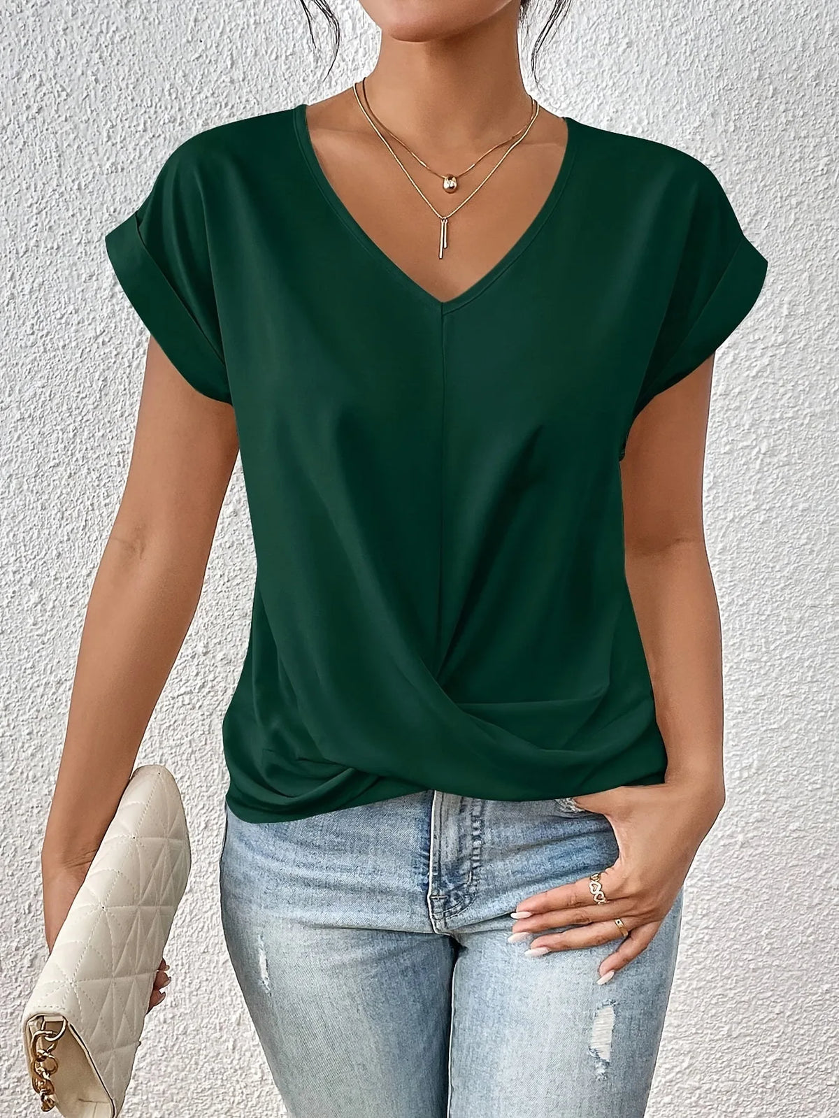 Dark green V-neck top showing the soft drape and twist-front knot detail at the waist