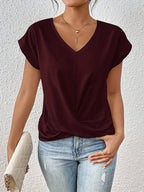Close-up front view of the beige top highlighting the fabric drape, V-neckline and centre seam stitching