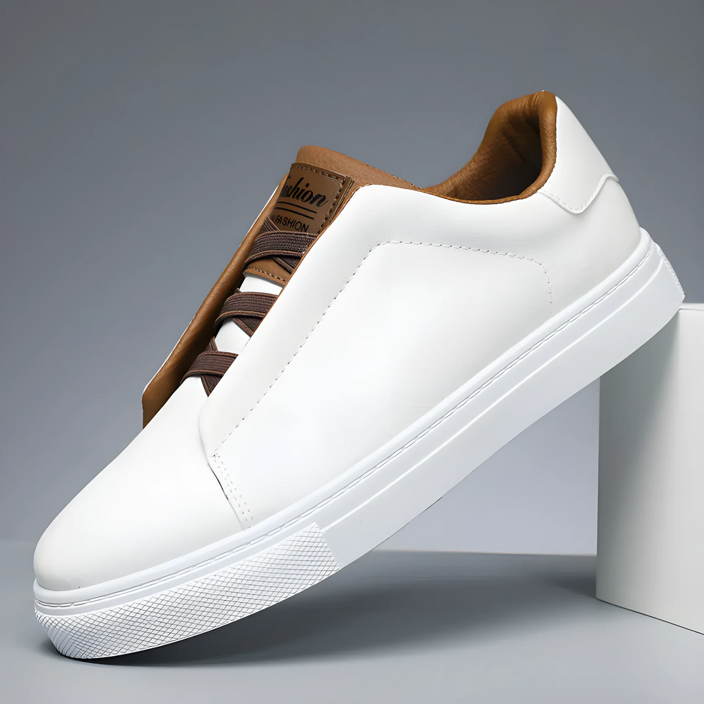 Close-up angled view of white trainer showing tan lace panel and textured white outsole