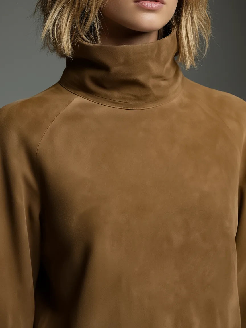Close-up of the tan suede polo neck collar and raglan seam detail on the shoulder