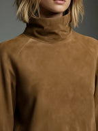 Close-up of the tan suede polo neck collar and raglan seam detail on the shoulder