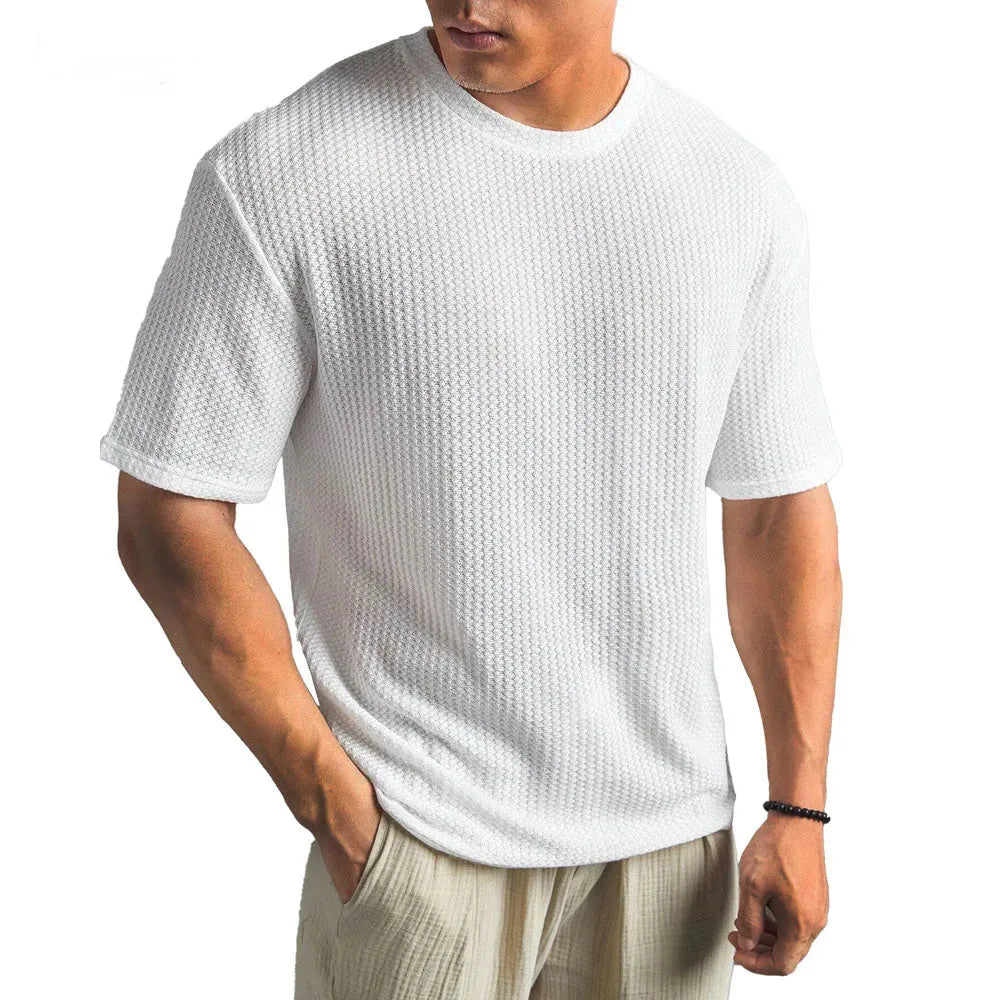 Man wearing a white waffle-knit crew neck T-shirt with short sleeves and a relaxed straight fit