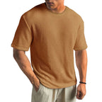 Close view of a rust brown textured T-shirt showing the waffle knit fabric and ribbed crew neckline